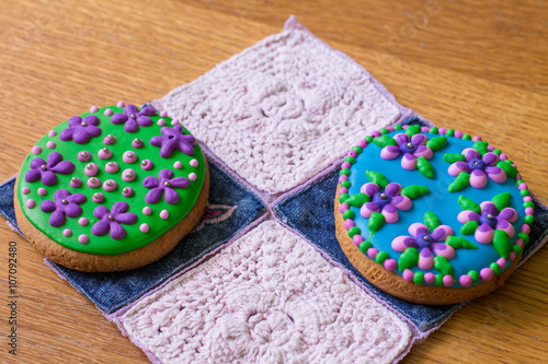 Two gingerbreads with flowers on napkin with knitting pattern. 