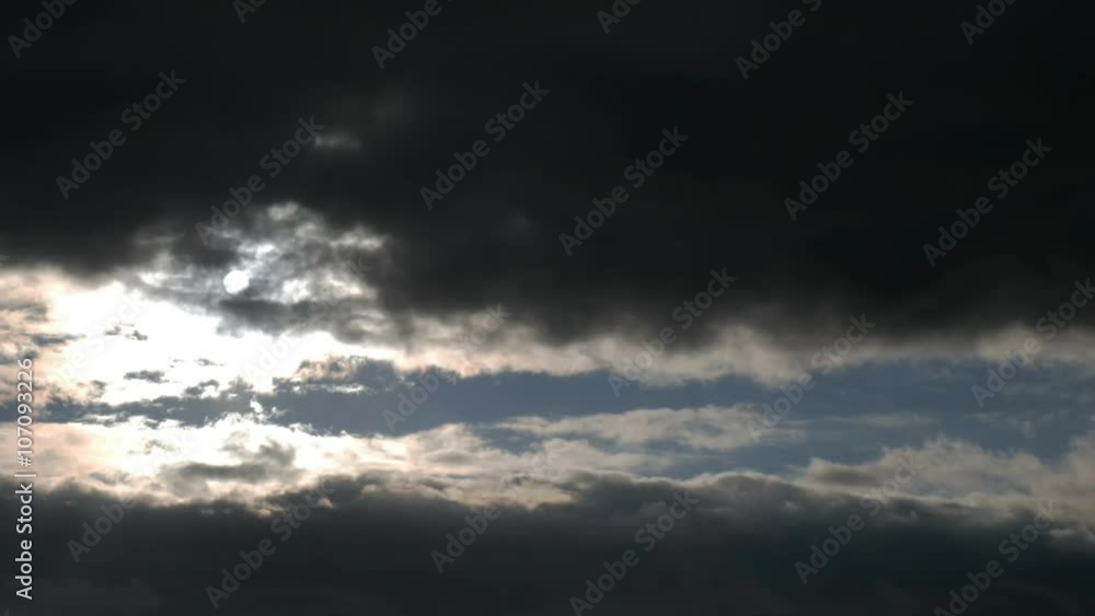 Cloudscape with sun shining behind dark storm clouds Cloudscape with sun shining behind dark storm clouds