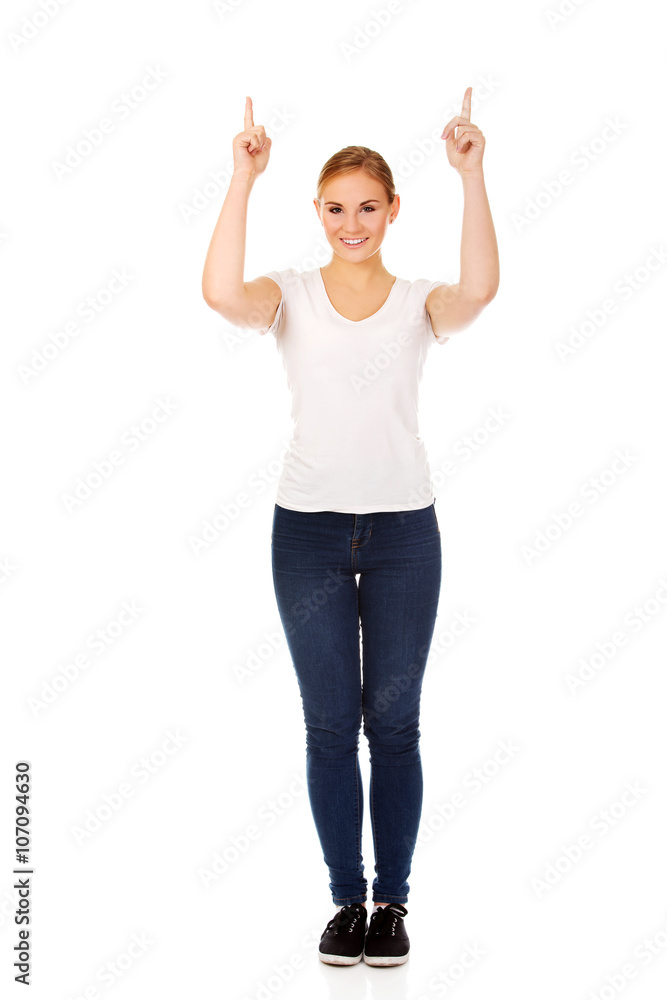 Happy young woman pointing up with both hands Happy young woman pointing up with both hands