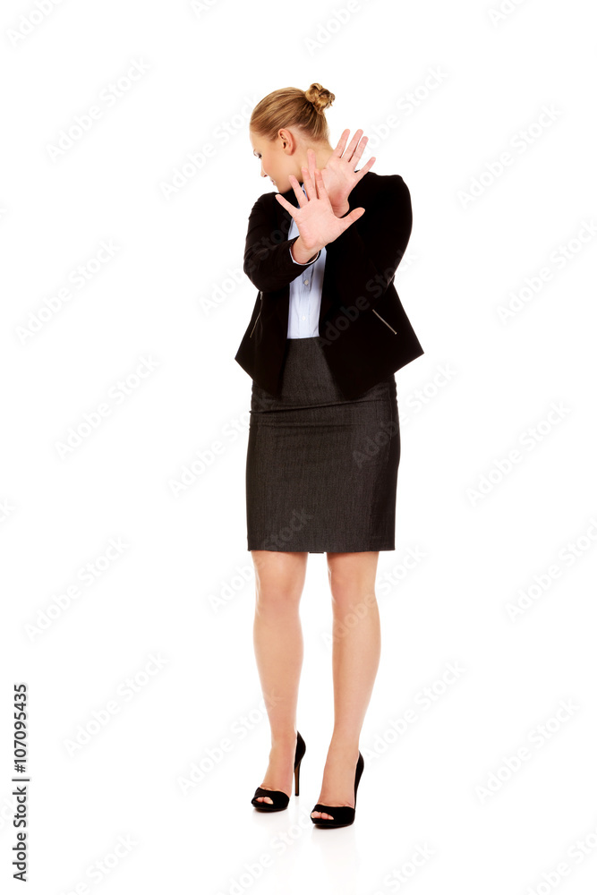 Young business woman trying to protect herself Young business woman trying to protect herself