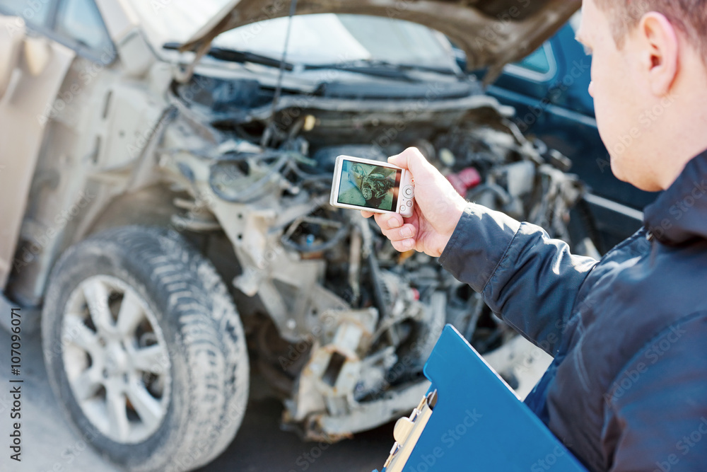 Insurance agent photographing car damage for claim form Insurance agent photographing car damage for claim form
