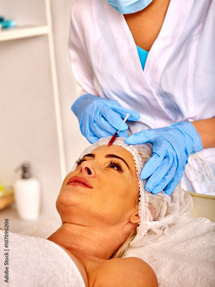 Woman middle-aged in spa salon with beautician. Beauty woman giving rejuvenating injections. Woman middle-aged in spa salon with beautician. Beauty woman giving rejuvenating injections.