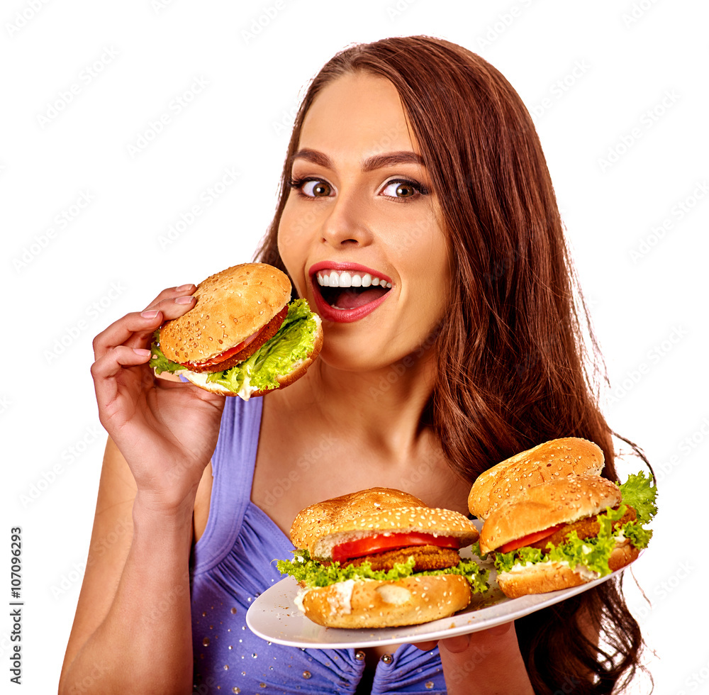 Girl holding and eating several hamburgers. Fastfood concept .