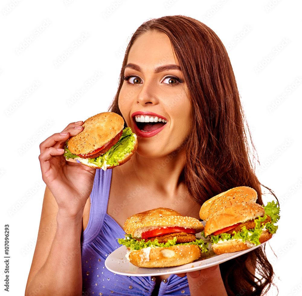 Girl holding and eating several hamburgers. Fastfood concept . Girl holding and eating several hamburgers. Fastfood concept .