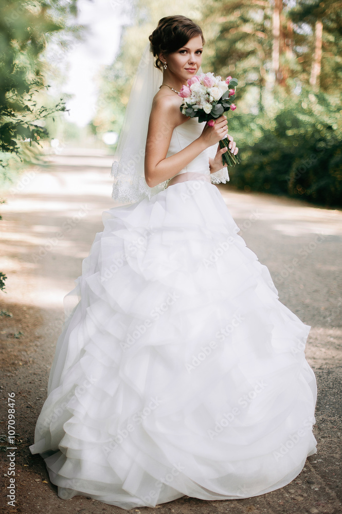 Beautiful bride woman portrait with bridal bouquet posing in her Beautiful bride woman portrait with bridal bouquet posing in her