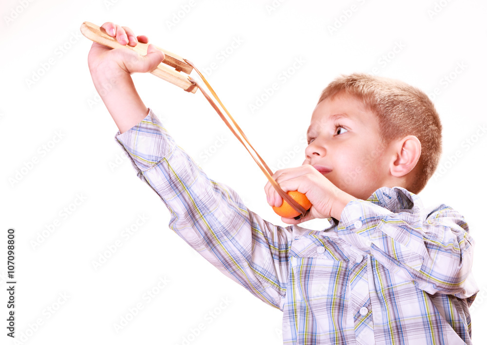 Young boy use sling shot shoot mandarine. Young boy use sling shot shoot mandarine.
