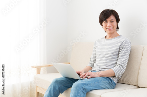 young asian man using laptop computer
