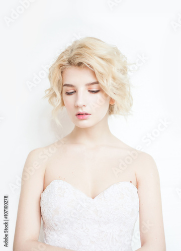 Woman with white hair in a white dress with Nude makeup on a white background