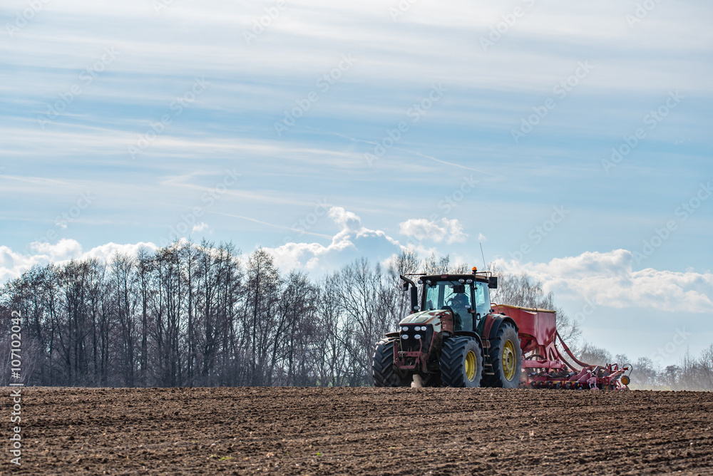 Fototapeta premium Tractor harrowing the field