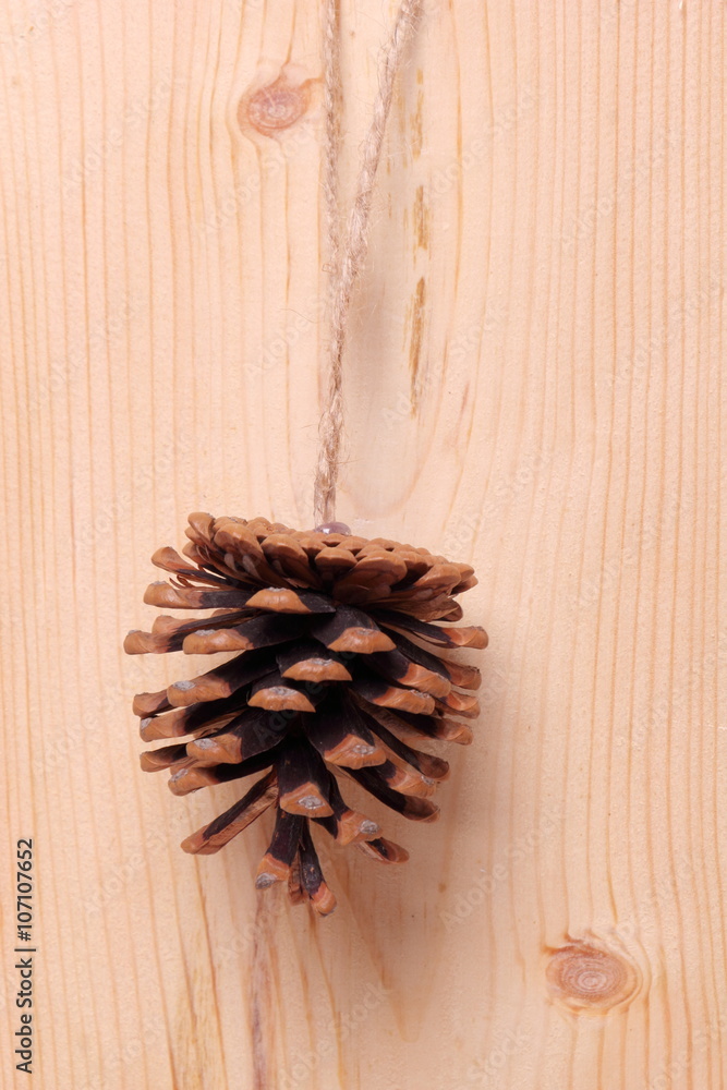 Pine cone with bow./Pine cone on a wooden background texture.