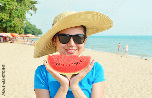 Young woman in big hat ad sunglasses with watermelon