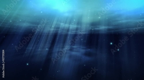 Underwater scene with rays of light shining below the water surface.