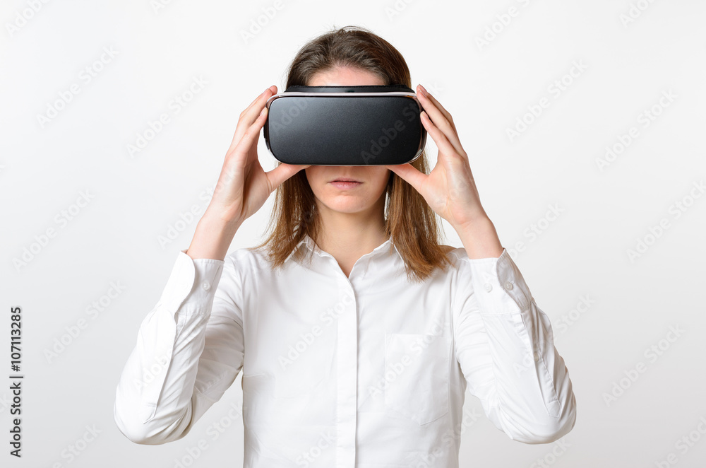 One woman holds virtual reality glasses to face
