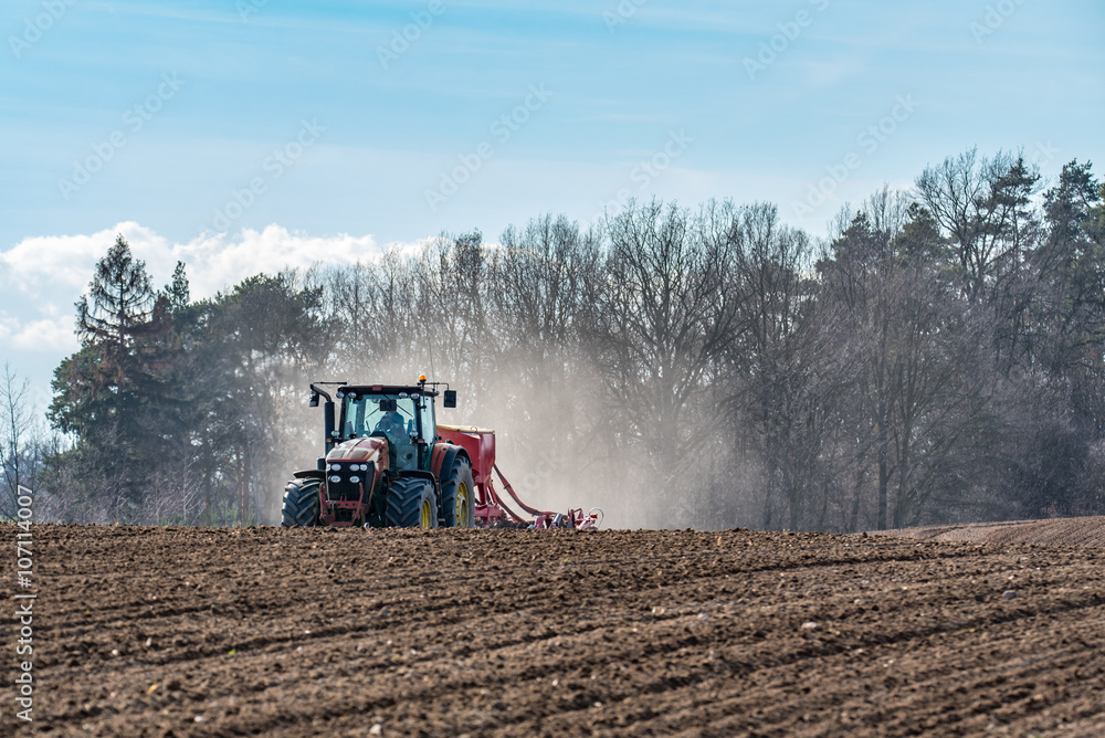 Fototapeta premium Tractor harrowing the field