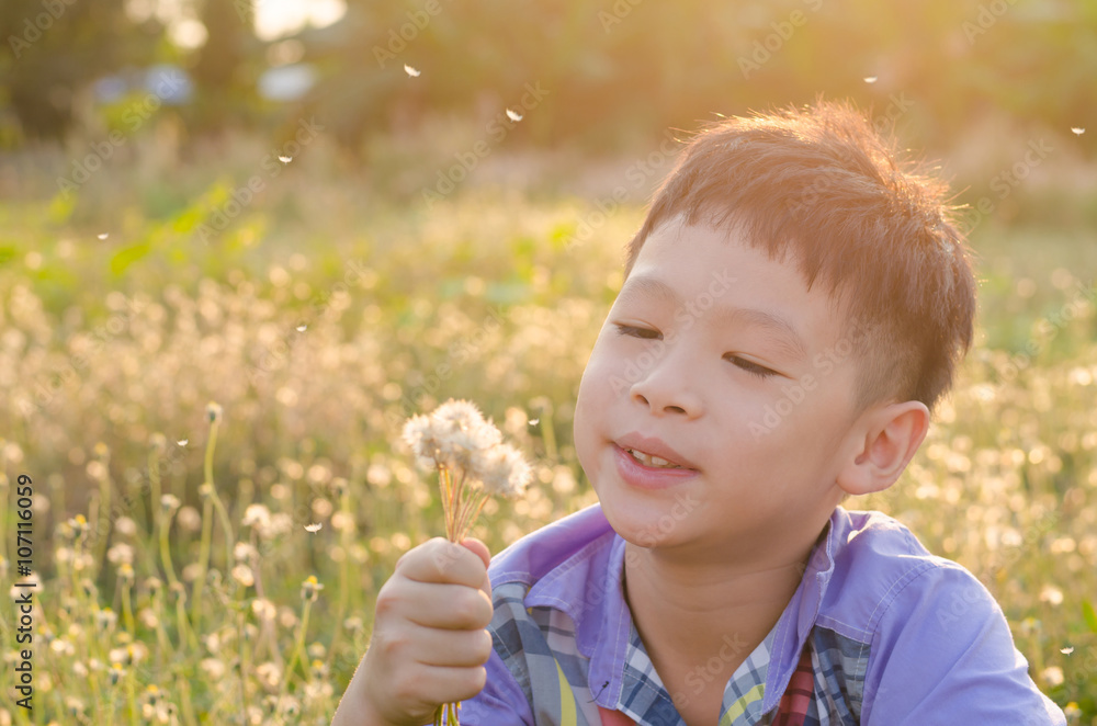 Asian child blowing away flower in spring Asian child blowing away flower in spring