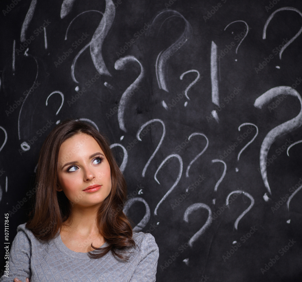 Young girl with question mark on a gray background Young girl with question mark on a gray background