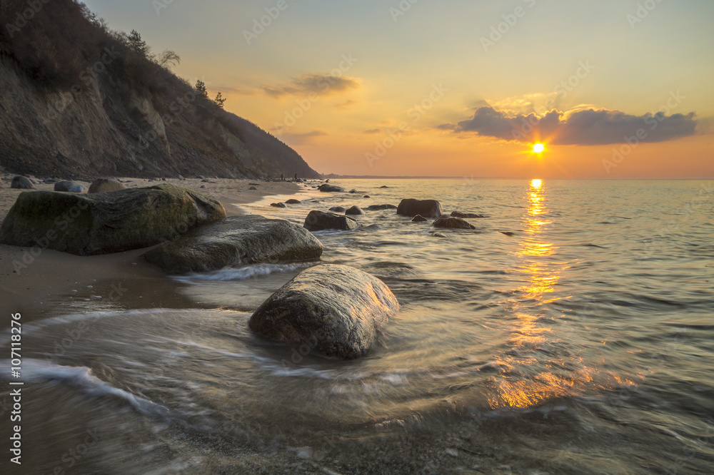 Obraz na płótnie Klif i plaża morska w świetle zachodzącego słońca w salonie