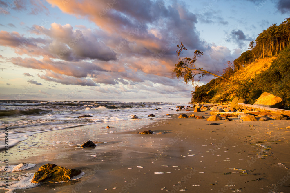 Obraz na płótnie Klif i plaża morska w świetle zachodzącego słońca w salonie