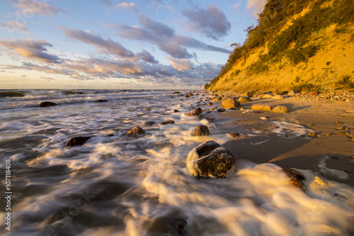 Klif i plaża morska w świetle zachodzącego słońca