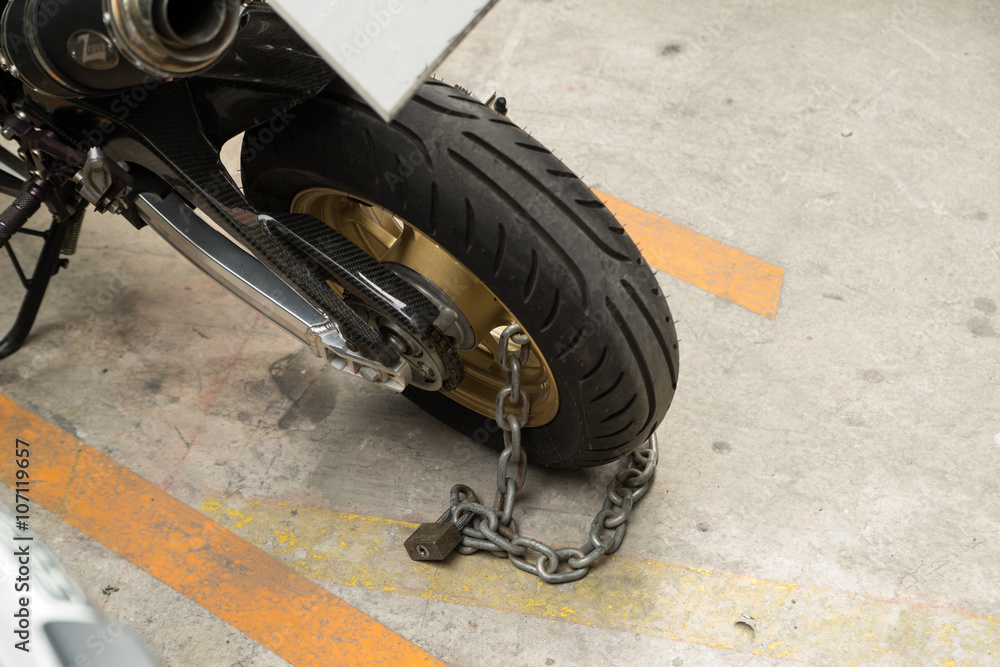 Obraz premium padlock security lock blocking the motorcycle wheel on street