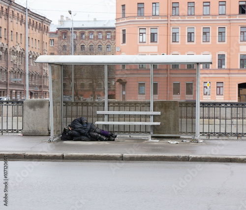 Fotografie homeless man sleeping at the bus stop
