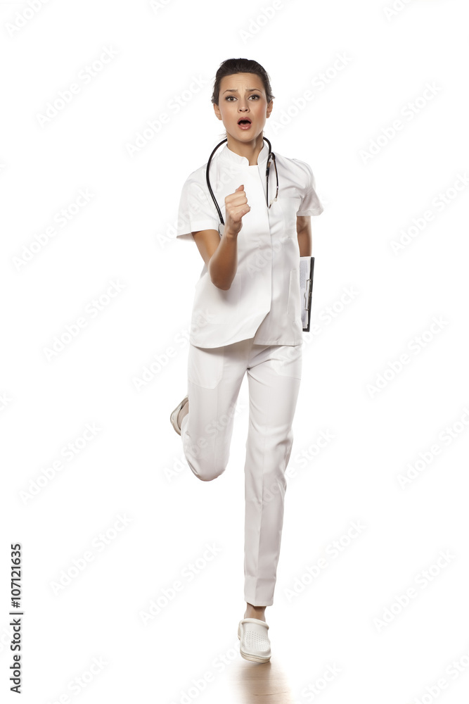 a young woman doctor in a panic run on a white background a young woman doctor in a panic run on a white background
