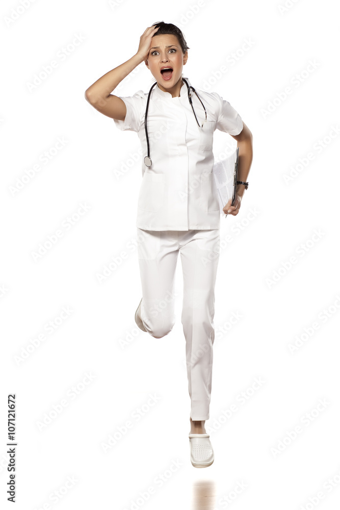 a young woman doctor in a panic run on a white background a young woman doctor in a panic run on a white background
