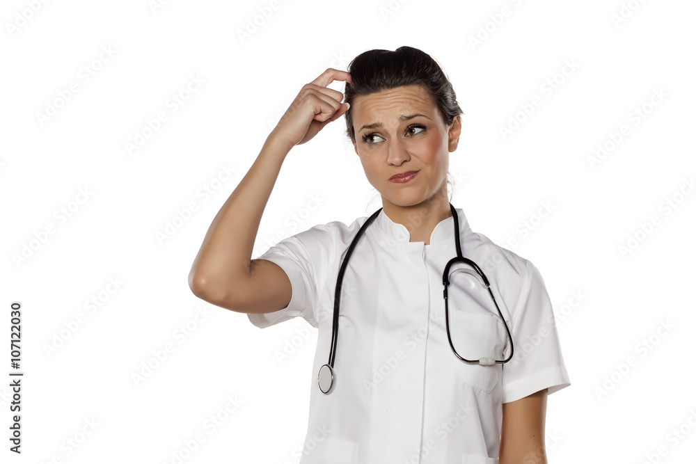 confused young woman doctor on a white background confused young woman doctor on a white background