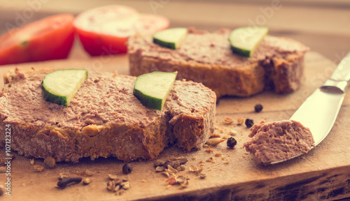 Salmon pate on bread and wooden background