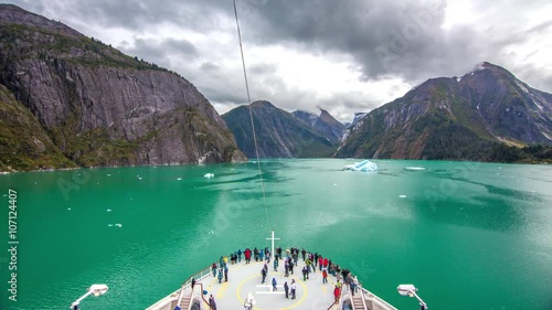 Alaska Tracy Arm Fjord Cruising Timelapse Part 1 Featuring the View from the Front of a Cruise Ship with Passengers on the Bow Enjoying the Scenery towards Sawyer Glacier. photo