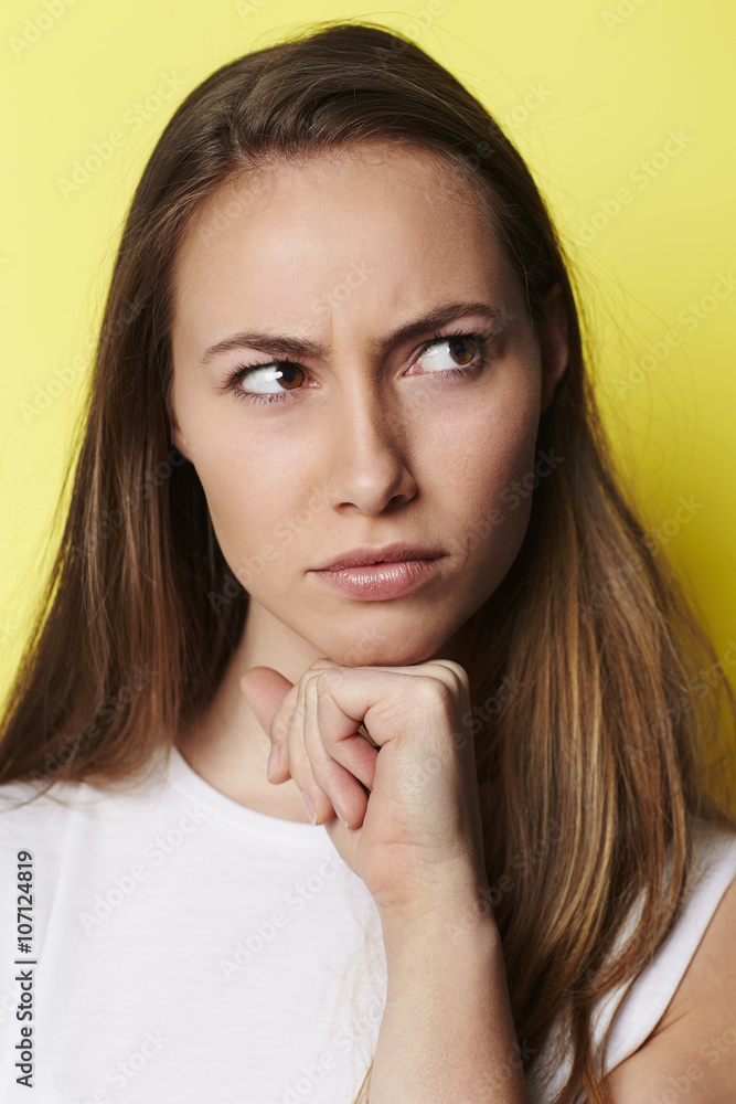 Frowning young woman in yellow studio Frowning young woman in yellow studio