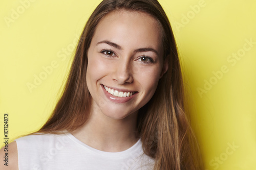 Brown eyed girl in yellow studio, portrait