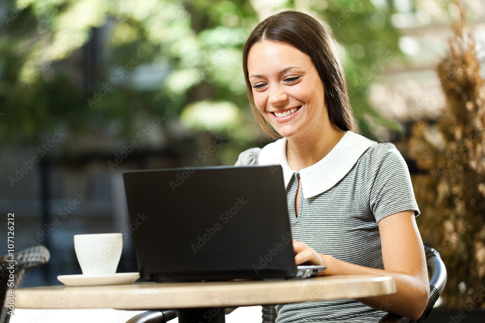 Young woman is using laptop in a cafe. Young woman is using laptop in a cafe.