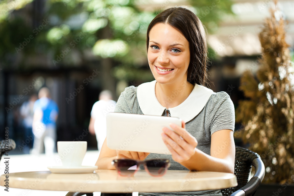 Young woman is using digital tablet in a cafe. Young woman is using digital tablet in a cafe.