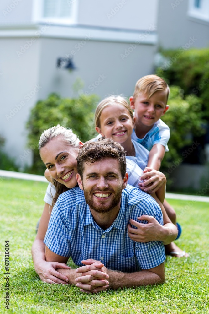 Happy family lying on top of each other in yard Happy family lying on top of each other in yard