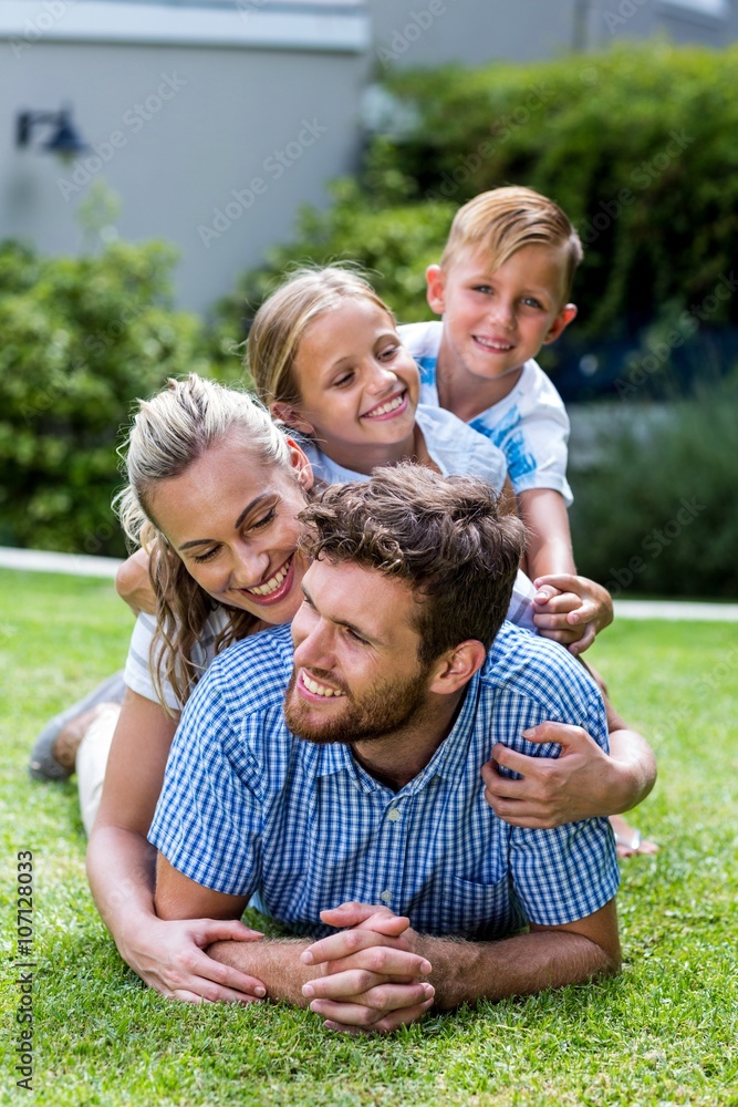 Happy family enjoying while lying on grass in yard 
