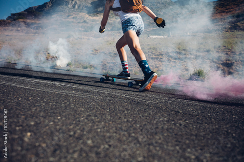 Young woman skateboarding on a road © Jacob Lund