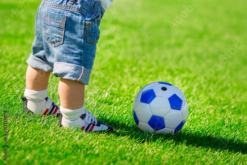 boy with a soccer ball on green grass © anna_burlakova