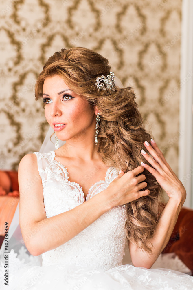 Beautiful young bride with a wedding bouquet sitting at the sofa. Beautiful young bride with a wedding bouquet sitting at the sofa.