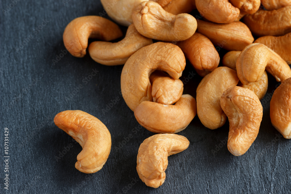 Roasted cashew nuts on dark background Roasted cashew nuts on dark background