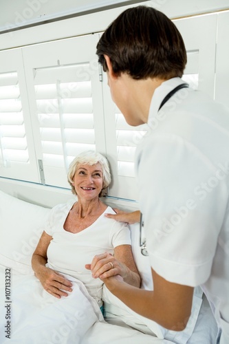 Rear view of doctor assisting senior woman