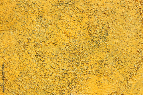 Shelled and cracked old painted yellow surface