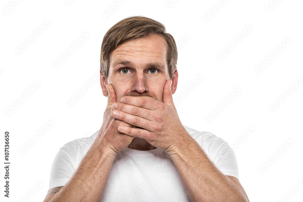 Man covering mouth with hands and looking at camera.