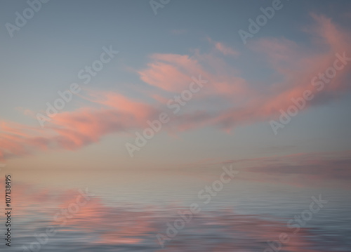 Dramatic sunset with clouds reflected in water.