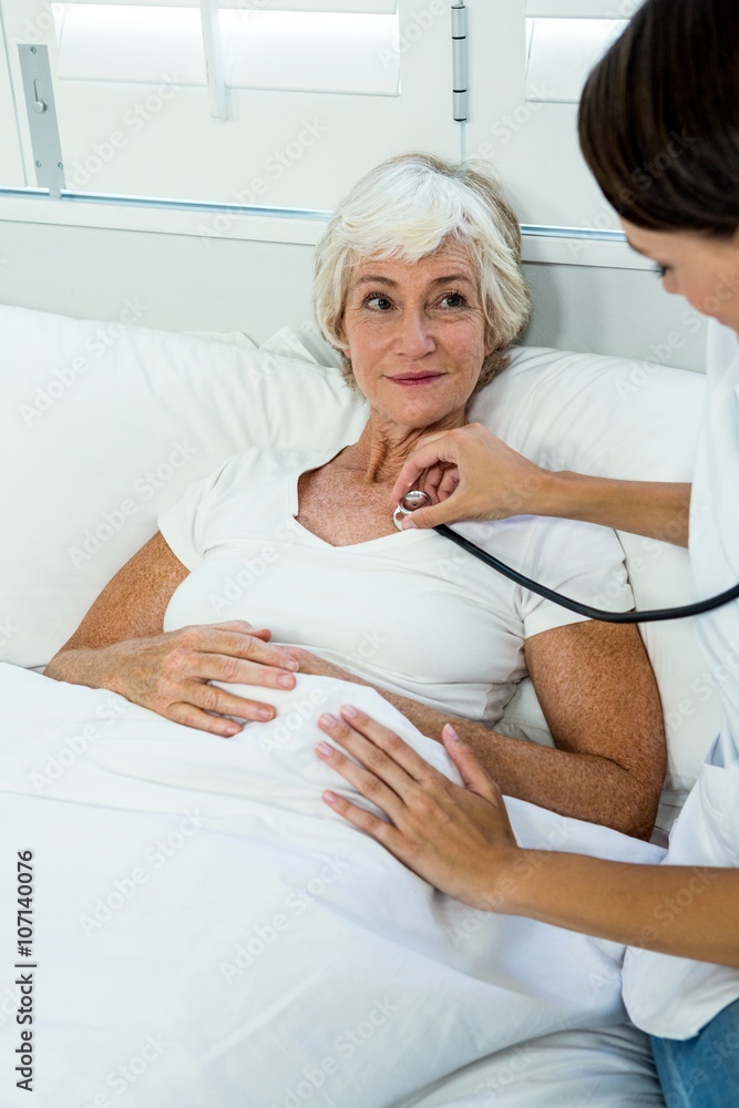 Female doctor auscultating old woman with stethoscope Female doctor auscultating old woman with stethoscope