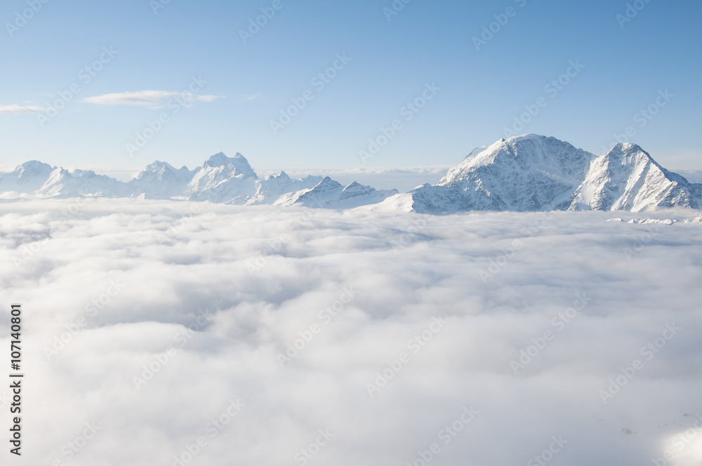 Chain of mountains sticking out of clouds