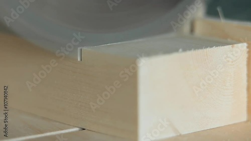 Electric saw starts to saw off a piece of wood