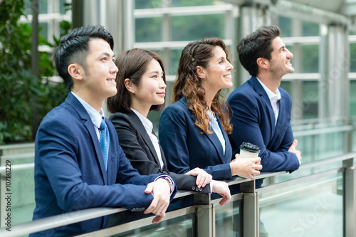 Business people look far away at outdoor photo