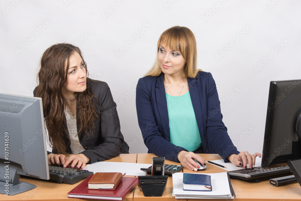 Office worker with superior looks at grim colleague sitting next Office worker with superior looks at grim colleague sitting next