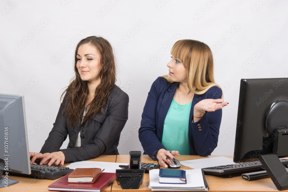 Office worker with indignation looking at quite a colleague sitting next to a computer Office worker with indignation looking at quite a colleague sitting next to a computer